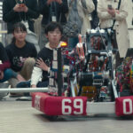 high school students watch the robot they created