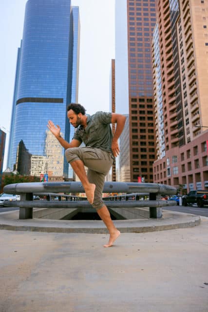 A man dances among the cityscape