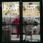 Graffitied glass doors to laundromat.