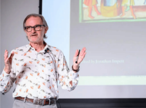 David Rosenboom lecturing with projected screen in background.