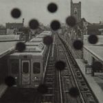 A train at left of the screen with black dots all over the image.