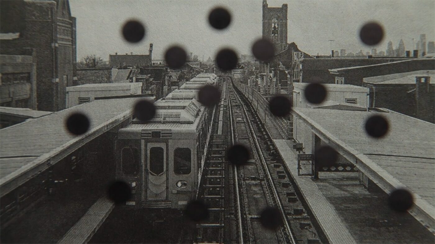A train at left of the screen with black dots all over the image.