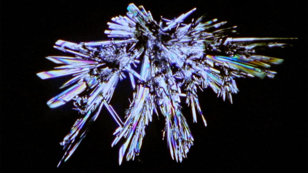 Silver crystalline form against black background