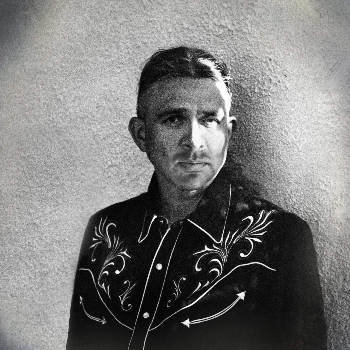 Black and white image of author Stephen Graham Jones in a three-quarter shot.