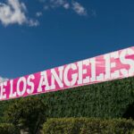 Pink Frieze Los Angeles banner atop hedges