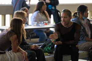 A group of people are seated at tables outside of CalArts