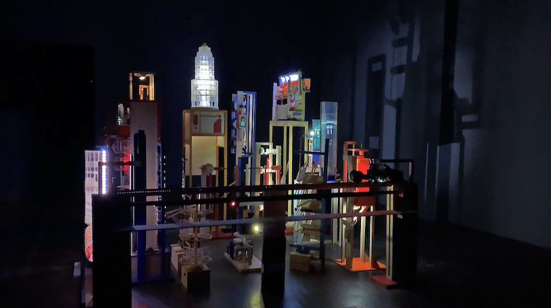 Colorfully lit cityscape diorama in a dark room