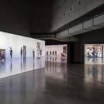 Videos of dancers in various movements and poses projected against four gallery walls