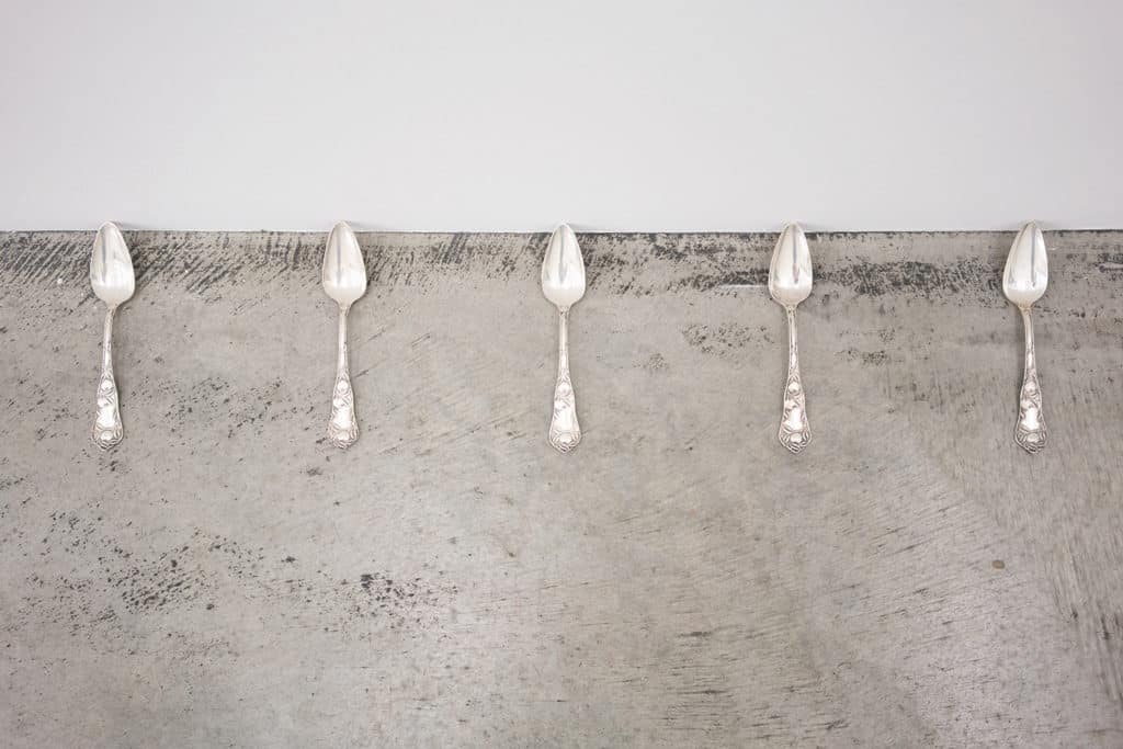 Five silver spoons lined up in a row