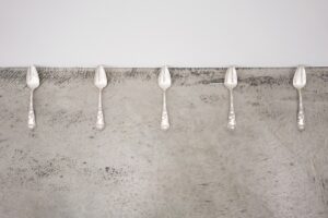 Five silver spoons lined up in a row