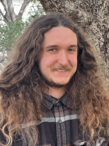 A headshot of Charlie Bohem in a plaid shirt.
