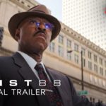 Courtney B. Vance as Jeremy Horne, wearing glasses, a hat, and suit and tie standing against multistory buildings