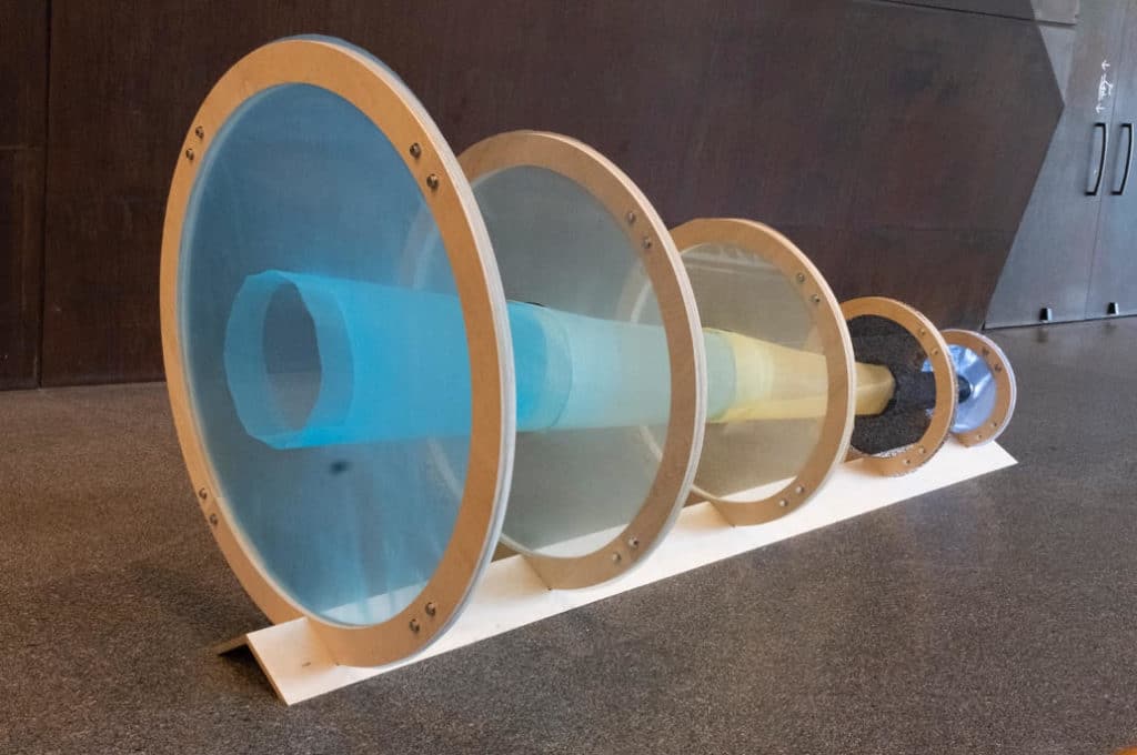 A sculpture of five circles surrounding a tube. 