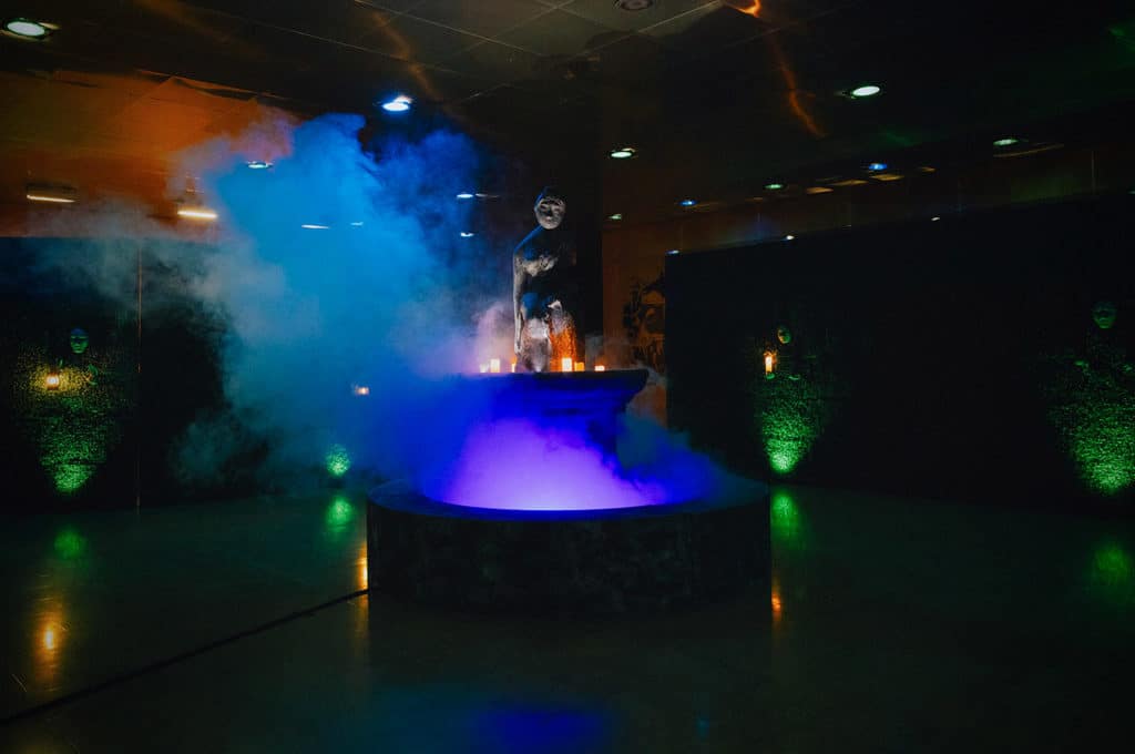 A Halloween decoration of a gothic fountain with blue smoke.