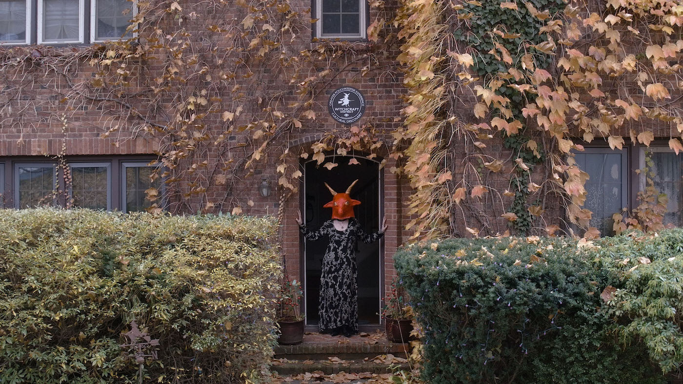 Still from Realm of Satan with a person in a devil mask seen in a doorway.