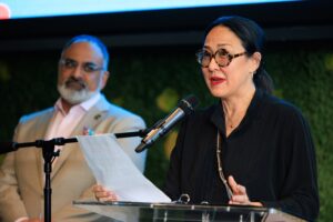 Ramsey Naito speaks at podium, with CalArts President Ravi Rajan standing behind her.