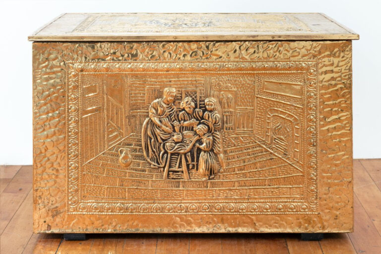 Picture of a gold box with a sculpted relief of a family on the front.