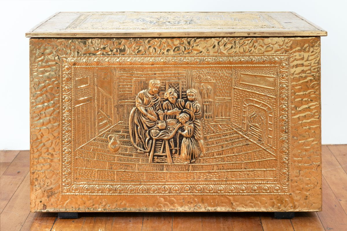 Picture of a gold box with a sculpted relief of a family on the front.