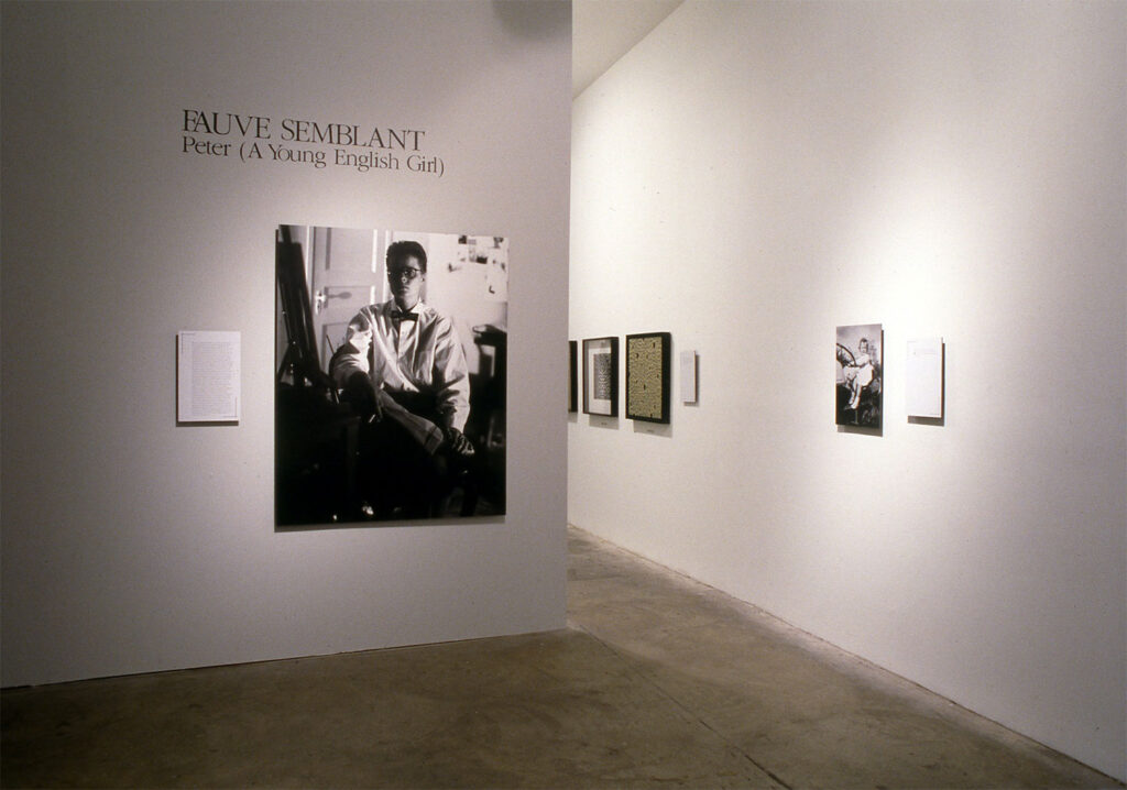 Gallery wall with black and white portrait beneath text 