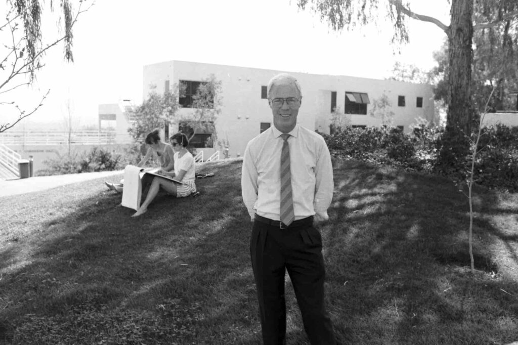 Bob Fitzpatrick in a white shirt and tie stands in front of Ahmanson Hall in 1986.