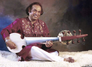 Aashish Khan smiling while playing sarod.