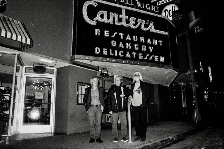 Suburban John members standing beneath Canter's Deli sign