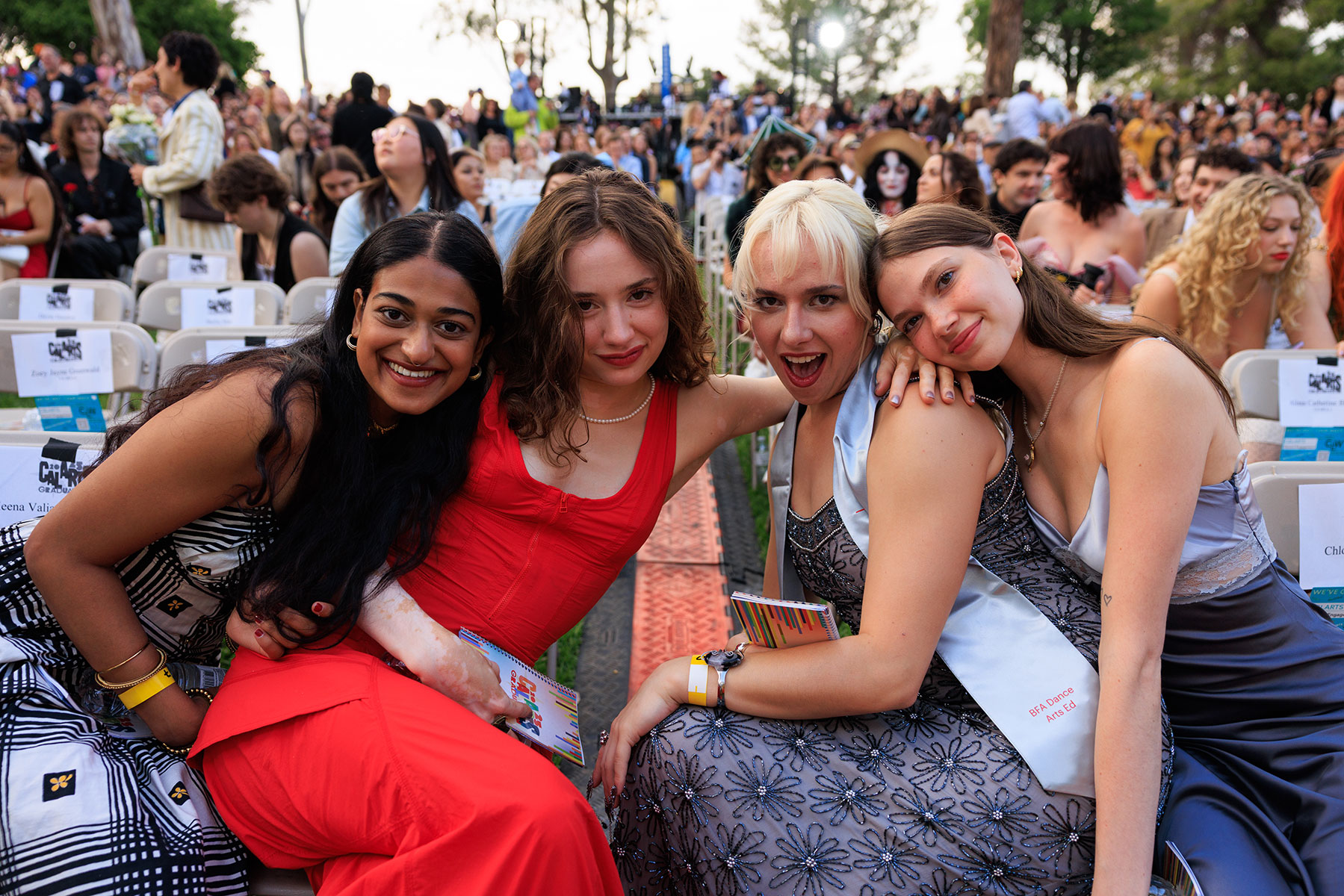 a group of women sit together in the front row of the CalArts 2025 graduation ceremony