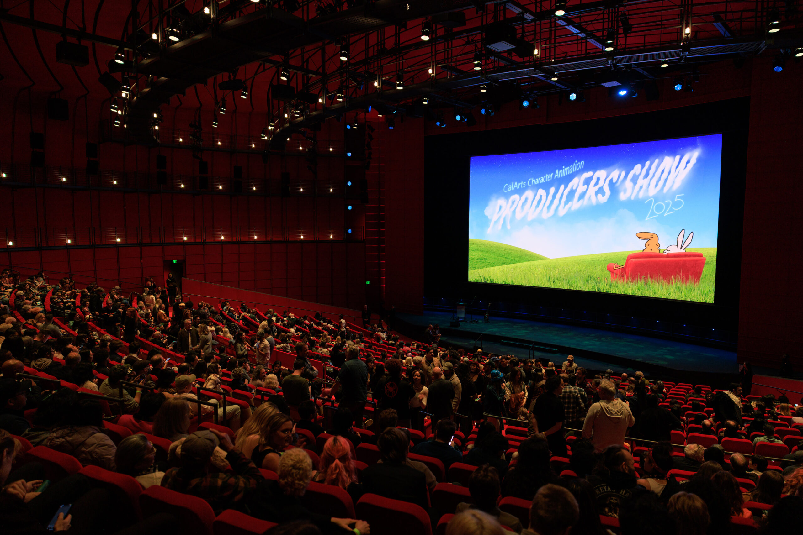 A theater filled with people watching a screen that reads 'CalArts Character Animation Producers' Show'