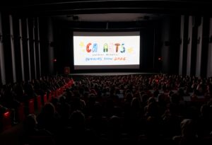 A dark theater filled with people with CalArts Character Animation Producers' Show on the screen.