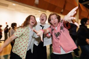 Three people jubilantly celebrate CalArts graduation 2026 in the Main Gallery.