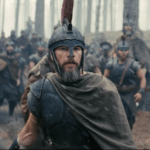Matt Damon as Odysseus, wearing armor and standing among soldiers in a forest in The Odyssey.