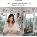 Artist Chelsea Byers stands in her studio, holding a blue and white ceramic piece, surrounded by various art pieces and decor.