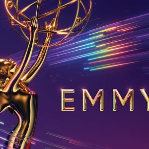 Closeup of Emmy Awards trophy against purple background and and rainbow streaks