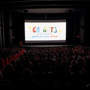 A dark theater filled with people with CalArts Character Animation Producers' Show on the screen.